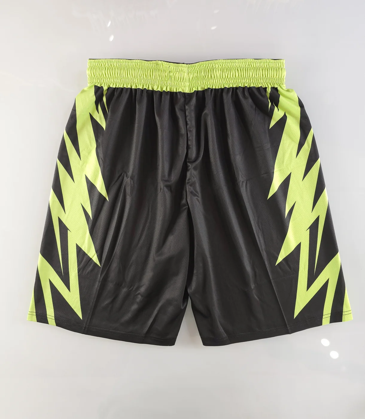 Back of matching black and neon green basketball shorts