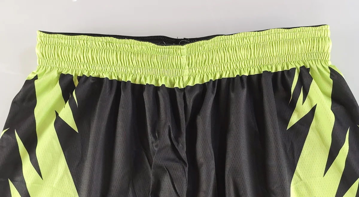 Close-up of elastic waistband on black and neon green basketball shorts
